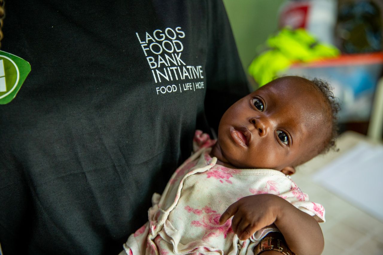 Crafting Captivating Headlines: Your awesome post title goes here A compassionate volunteer holds a baby at the Lagos Food Bank to support vulnerable children.